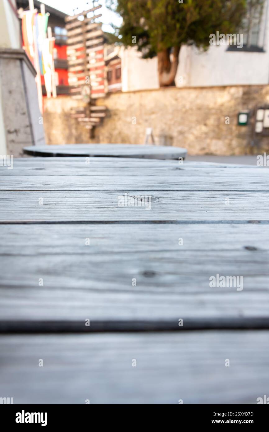 Struttura in legno invecchiato negli interni della strada - primo piano di tavole di legno grigie su un tavolo con sfondo sfocato, spazio copia Foto Stock