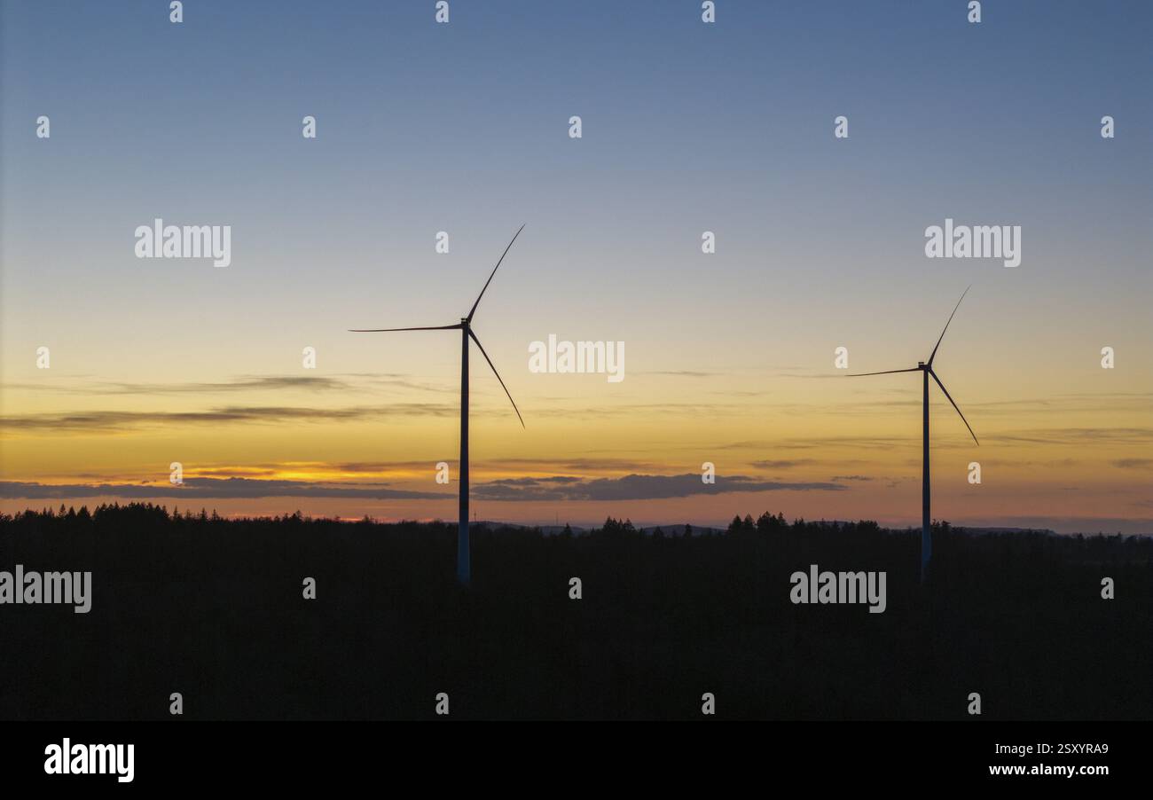 Due turbine eoliche in primo piano in un colorato cielo serale, Baden-Wuerttemberg, Germania, Europa Foto Stock