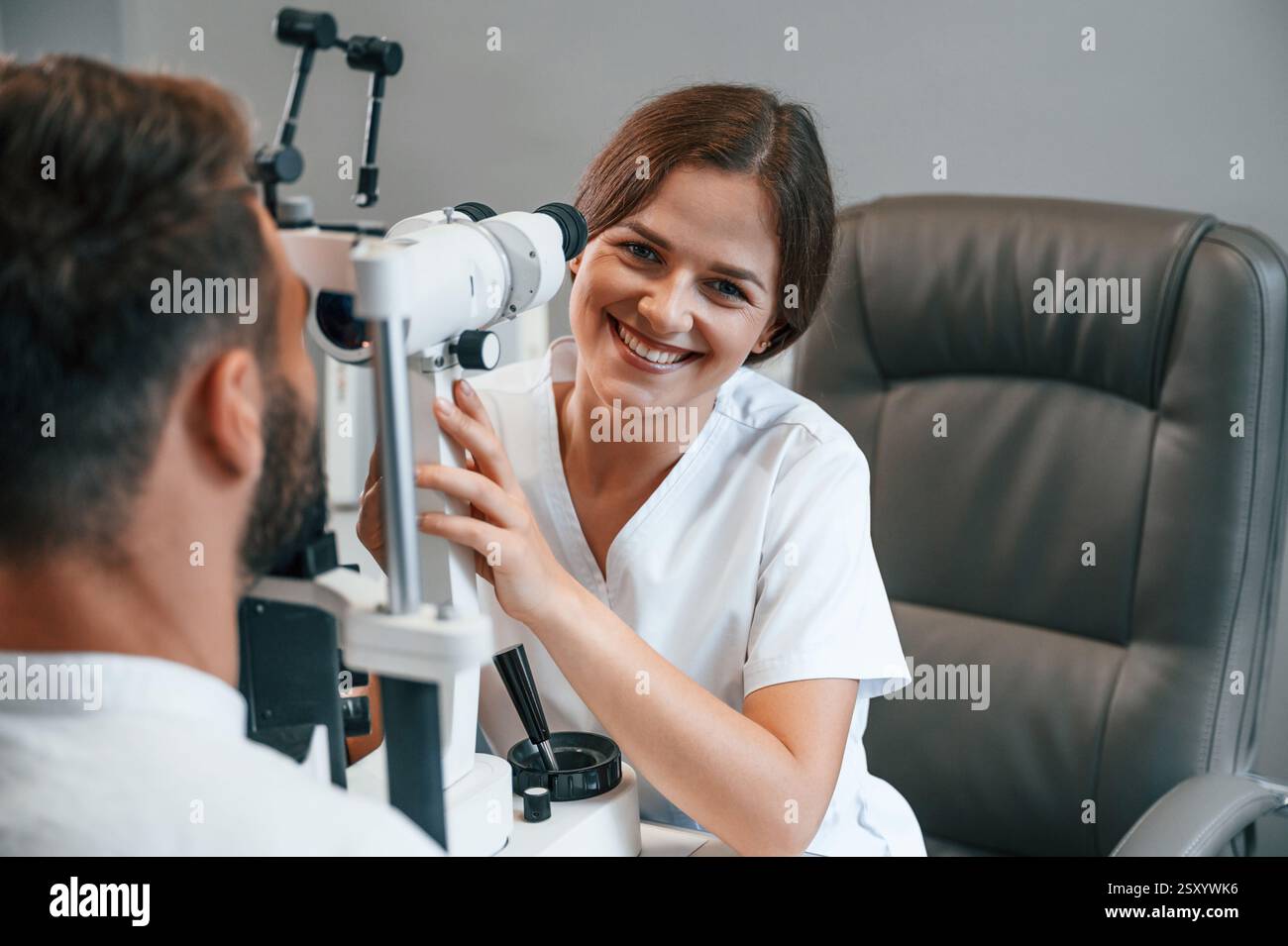 Tecnologie moderne. Visione dell'uomo controllata dal medico in clinica utilizzando uno speciale dispositivo optometrico. Foto Stock