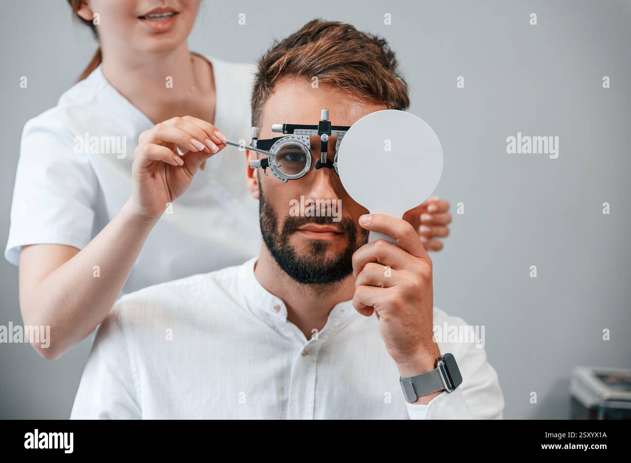 Dispositivo optometrico. La visione dell'uomo è stata controllata da una dottoressa donna in clinica. Foto Stock