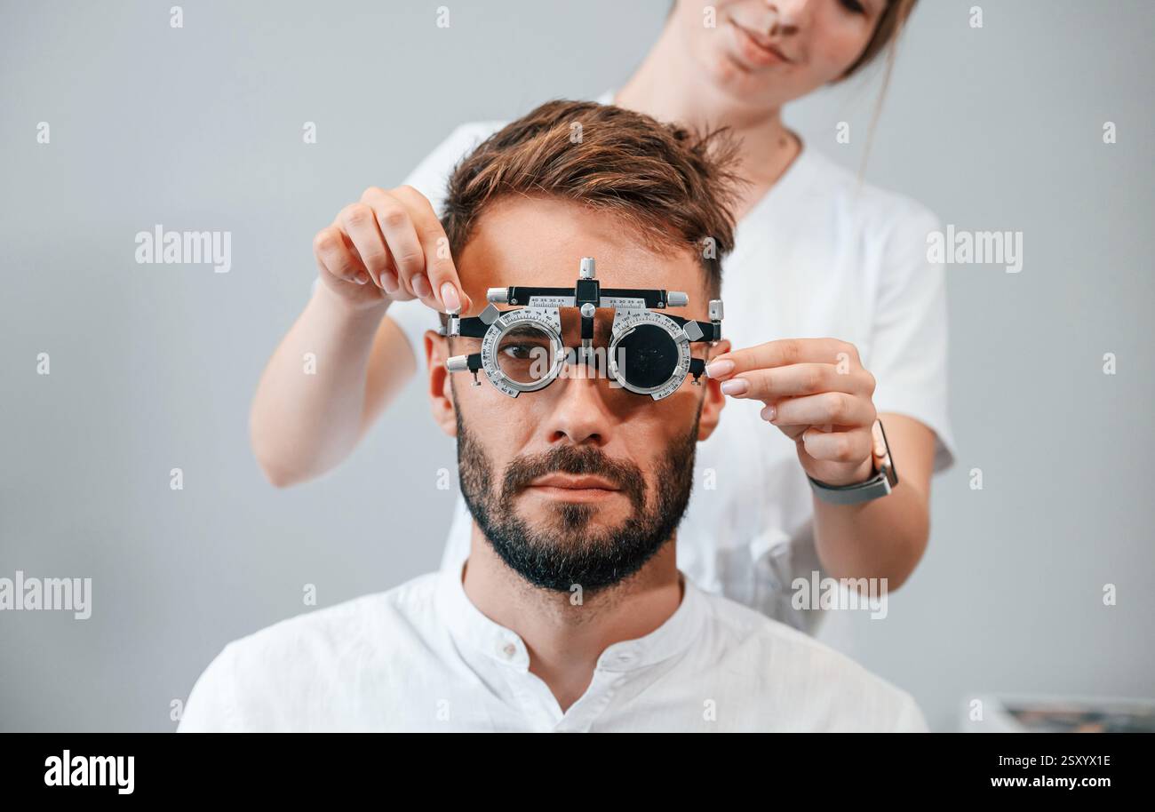Dispositivo optometrico. La visione dell'uomo è stata controllata da una dottoressa donna in clinica. Foto Stock