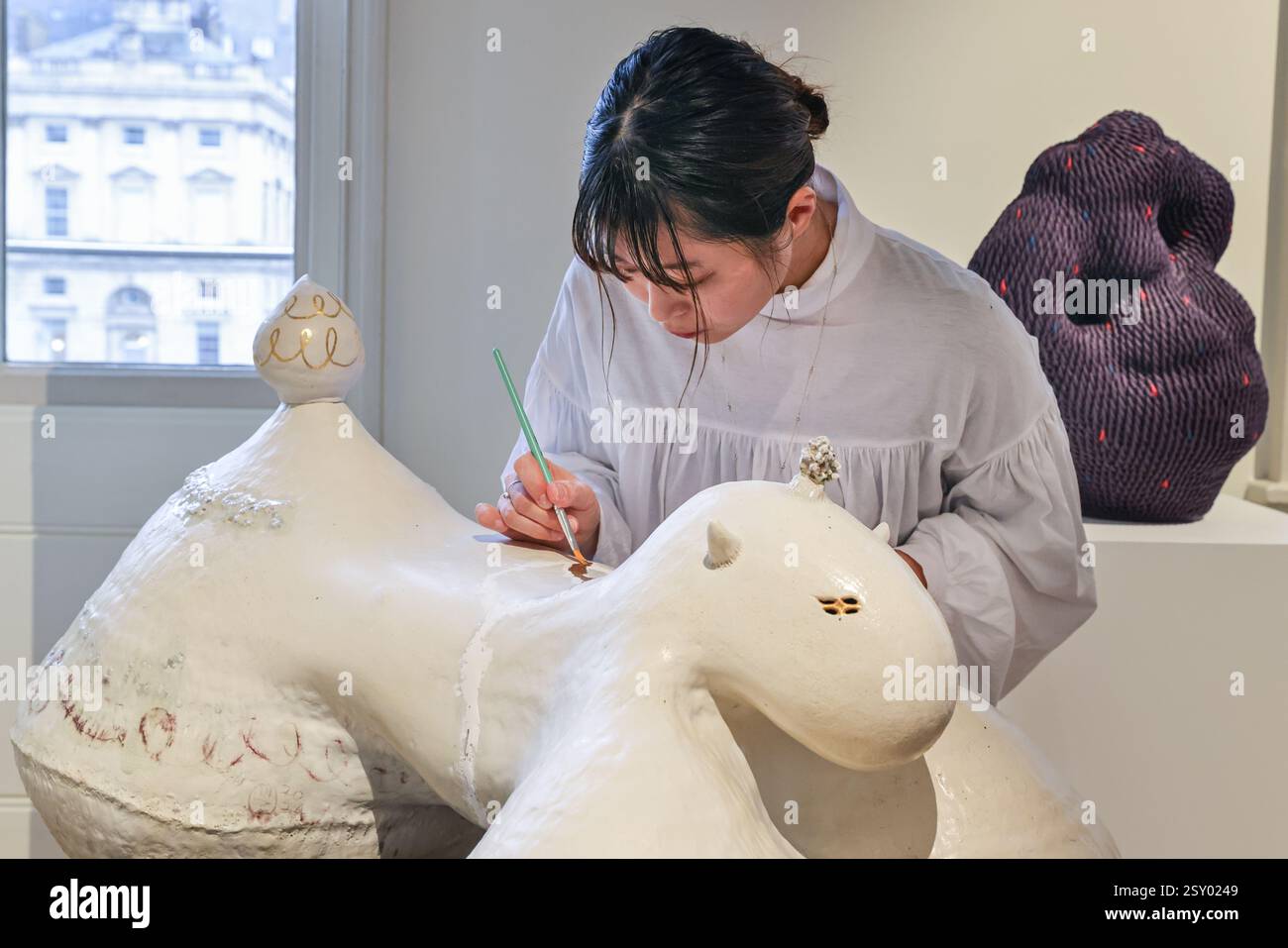 Londra, Regno Unito. 26 febbraio 2025. L'artista Teruri Yamawaki esegue alcuni lavori di rimediazione al suo pezzo "Sendo - The Lead", che a sua volta diventa parte del lavoro alla Galleria AIFA. Collect festeggia quest'anno i 21 anni di fiera internazionale dell'arte e del design contemporanei. Collect 2025 è presentato dal Crafts Council e si svolge dal 28 febbraio al 2 marzo 2025 a Somerset House. Crediti: Imageplotter/Alamy Live News Foto Stock