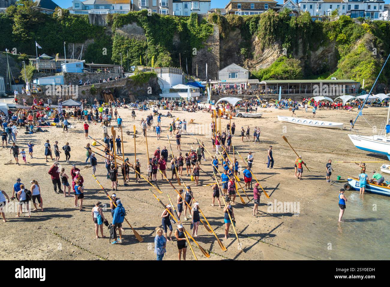 Gli equipaggi dei Pilot Gig che trasportano i loro remi in attesa di salire a bordo dei Pilot Gigs per l'evento femminile Newquay County Championships Cornish Pilot Gig Rowing a Newqu Foto Stock