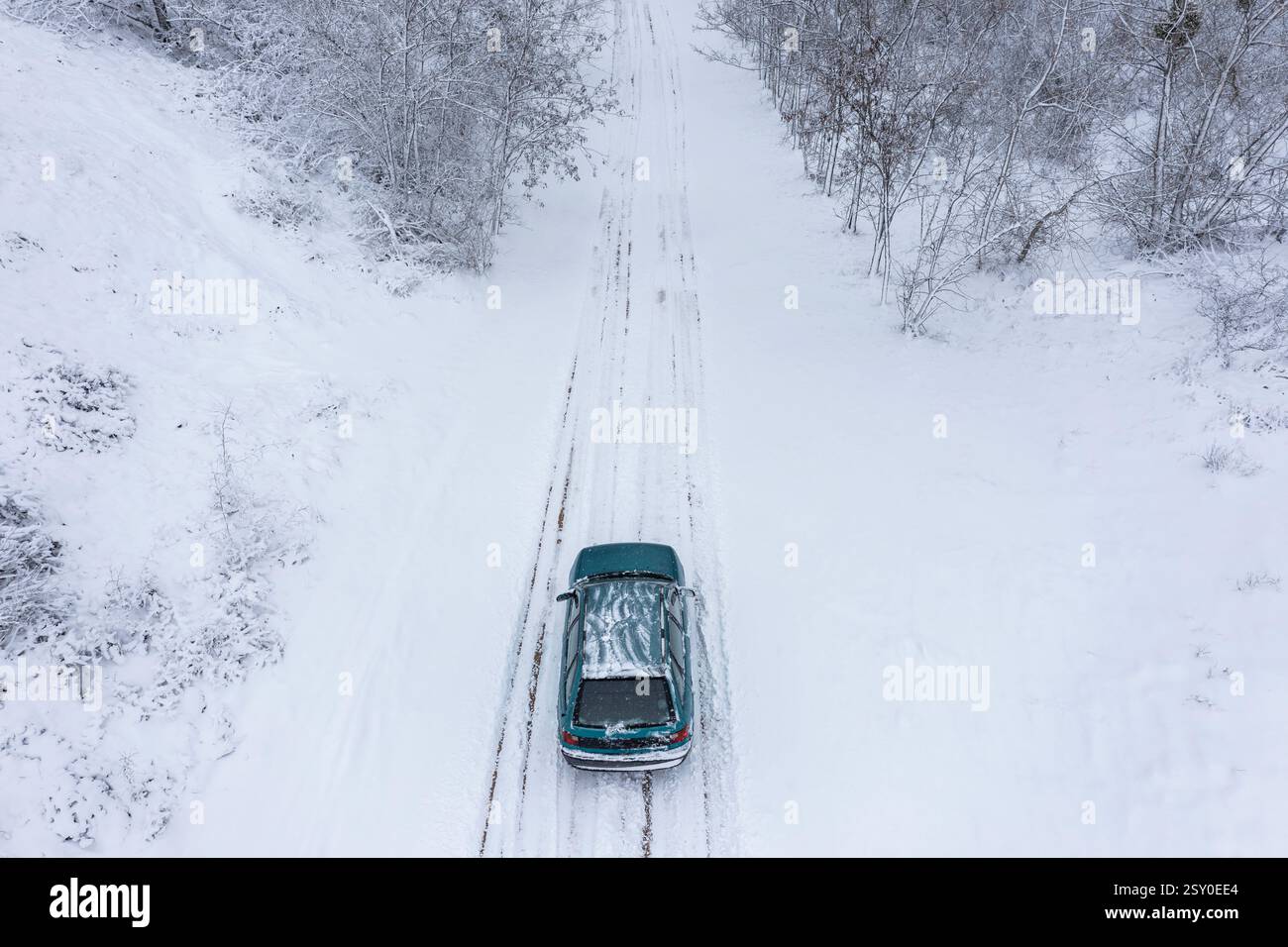 Vista aerea di un'auto che viaggia su strade ghiacciate nella foresta Foto Stock