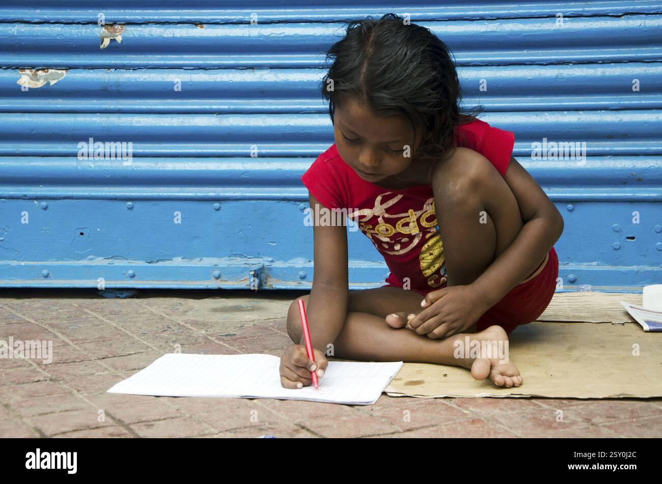Ragazza che studia sul sentiero a Kolkata Bengala Occidentale India Asia Foto Stock