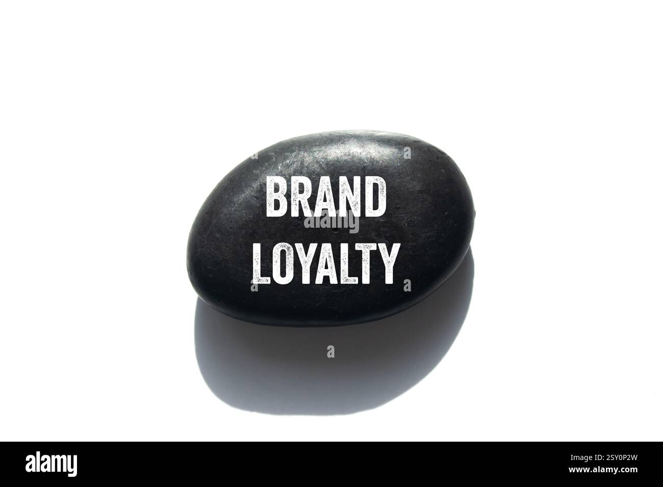 Messaggio di fedeltà al marchio scritto su pietra nera su sfondo bianco. Simbolo concettuale di fedeltà al marchio. Copia spazio. Foto Stock