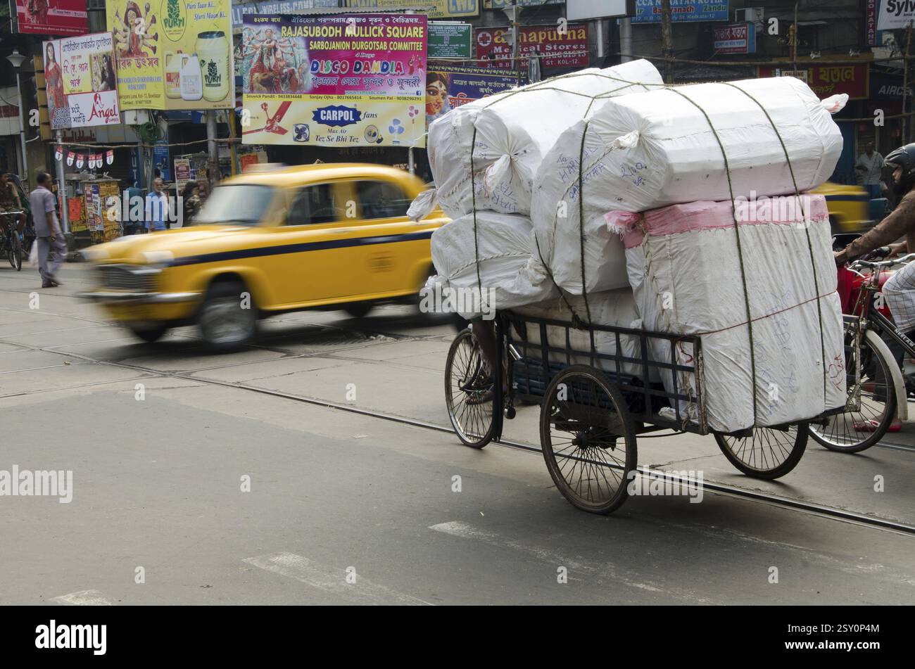 Pedalare in risciò attraversando la strada Kolkata Bengala Occidentale India Asia Foto Stock