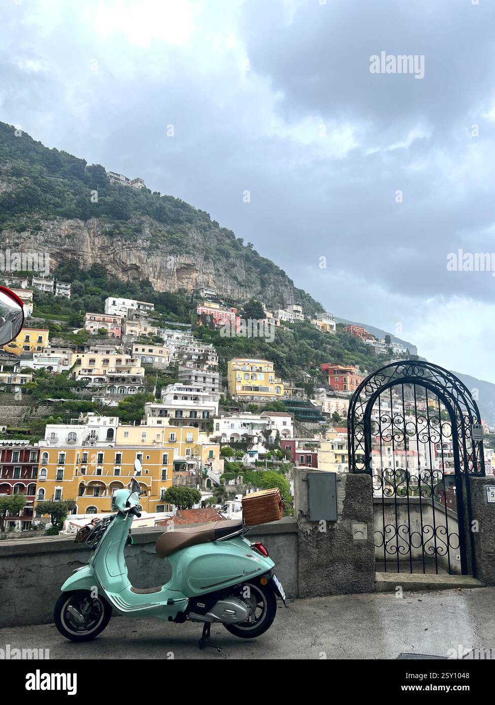 Vespa verde menta con vista sull'iconica collina di Positano - Immagine stock catturata con smartphone