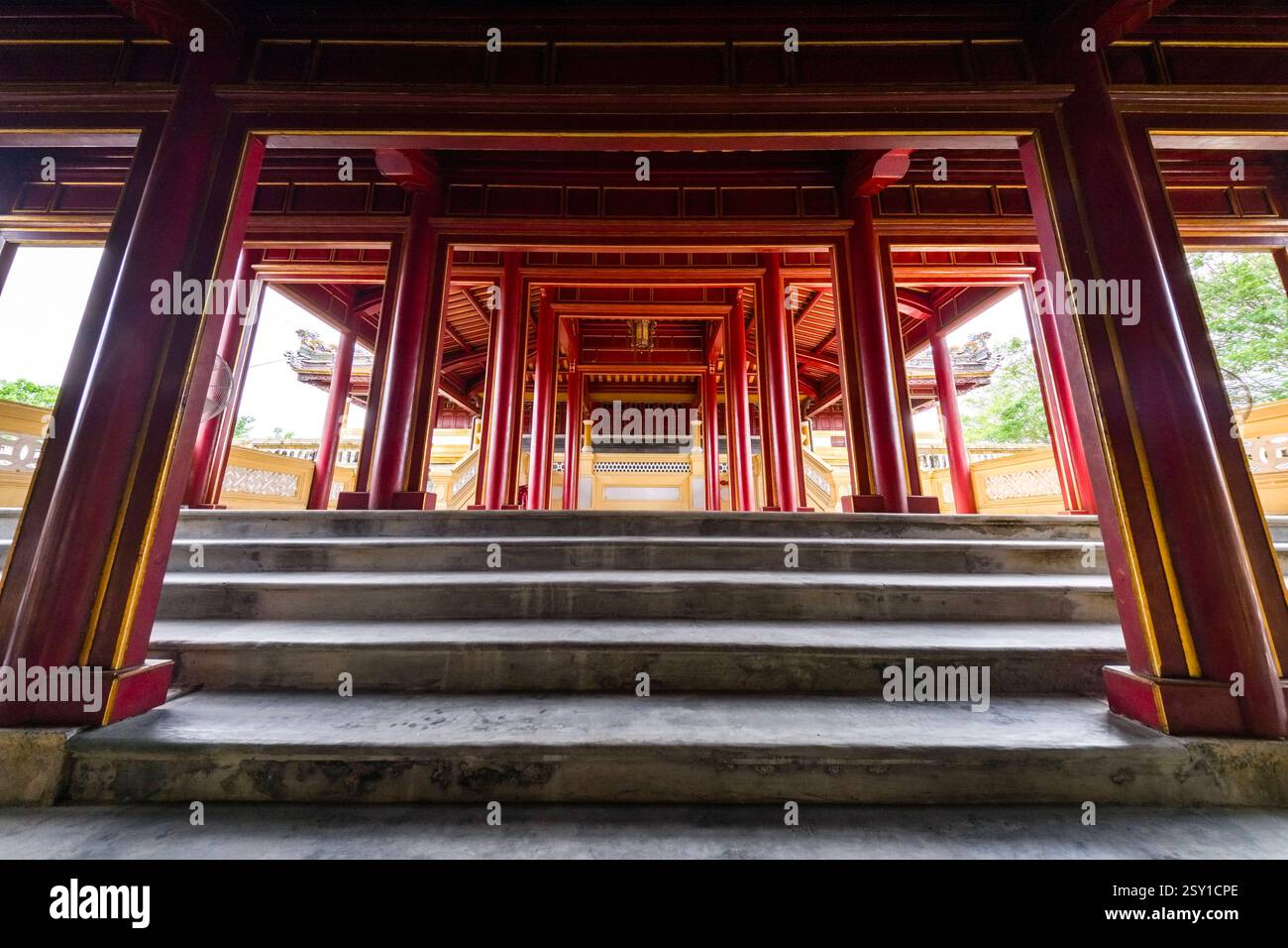 Colonne di colore rosso fiancheggiano una scalinata che conduce all'ex sala del Buddha del Re, Nhat Thanh Lau, Nháºt ThÃ nh lÃu, parte della cittadella di Hue, HoÃ ng ThÃ nh. Foto Stock