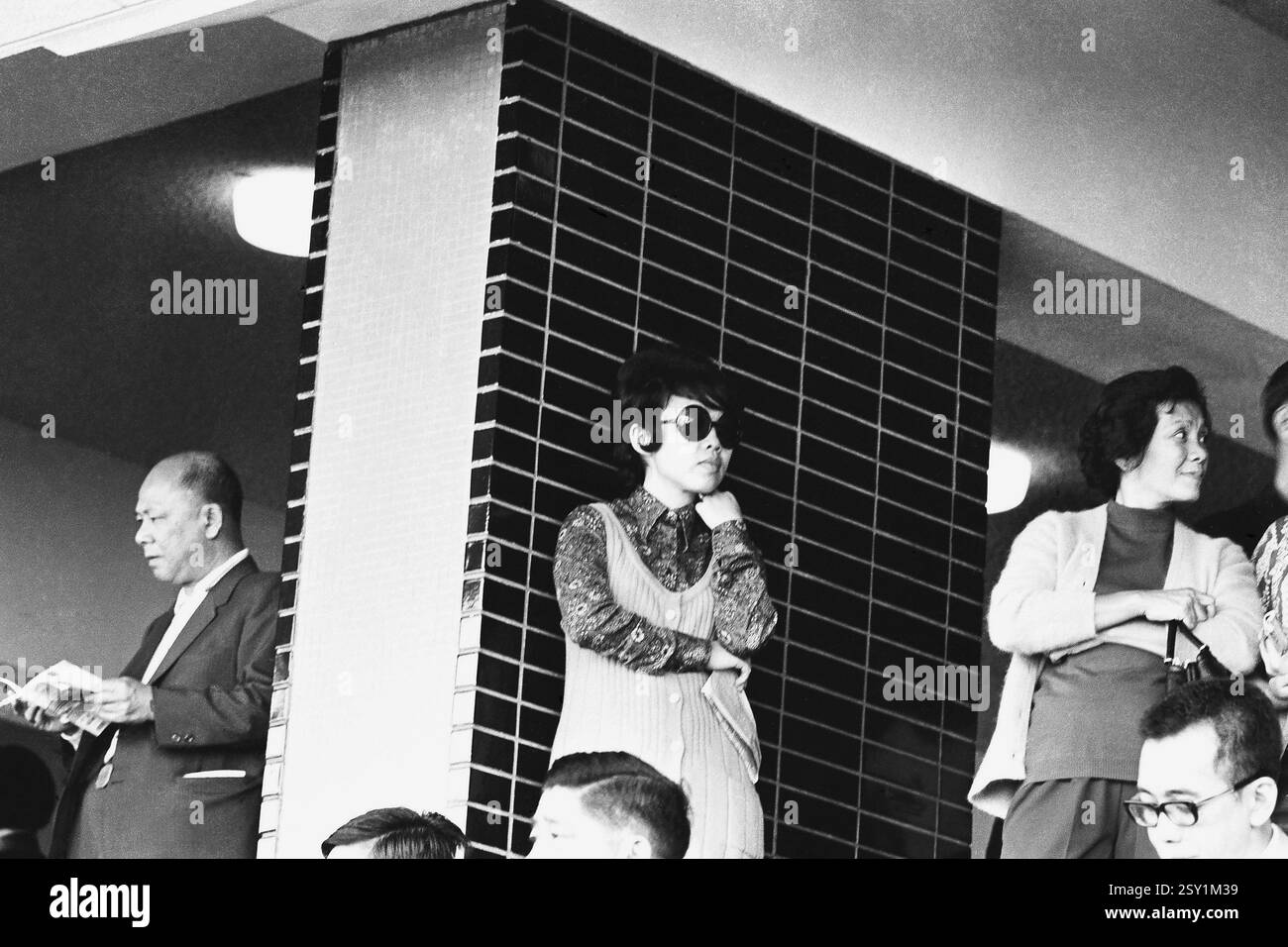 Persone in piedi ansiose al circuito di Hong Kong 1971 Foto Stock