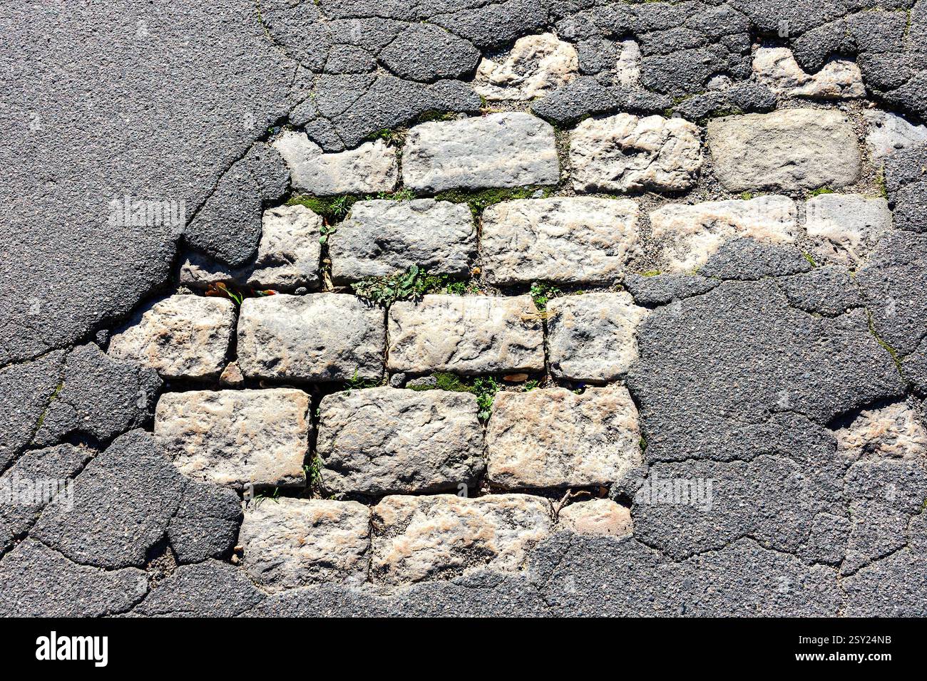 Superficie stradale rotta che rivela vecchi insediamenti in pietra - Tours, Indre-et-Loire (37), Francia. Foto Stock