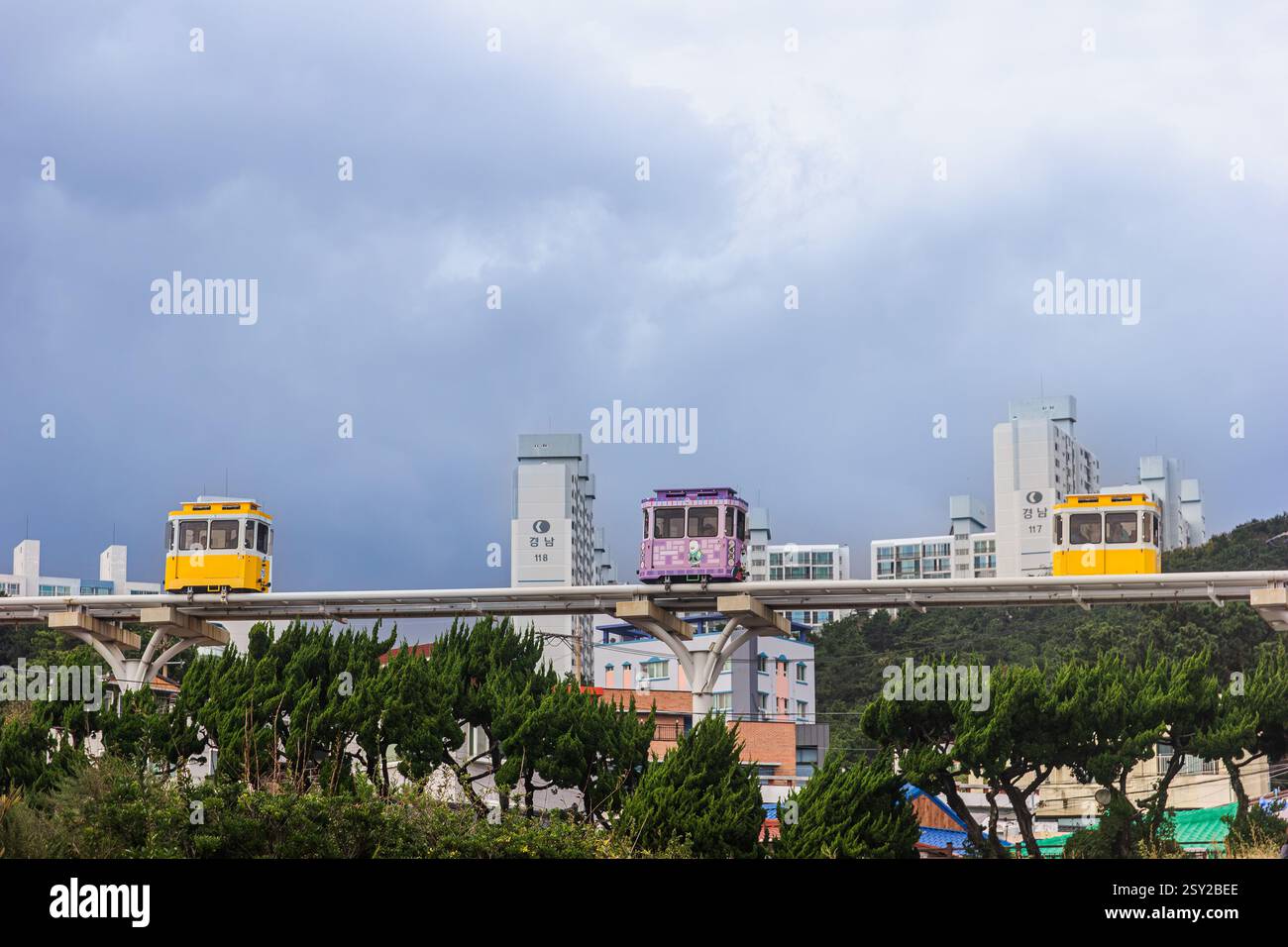 Busan, Corea del Sud - 29 ottobre 2024: Colorati treni a capsula del cielo sulla Busan Green Railway, con un sentiero a piedi e un paesaggio panoramico. Foto Stock