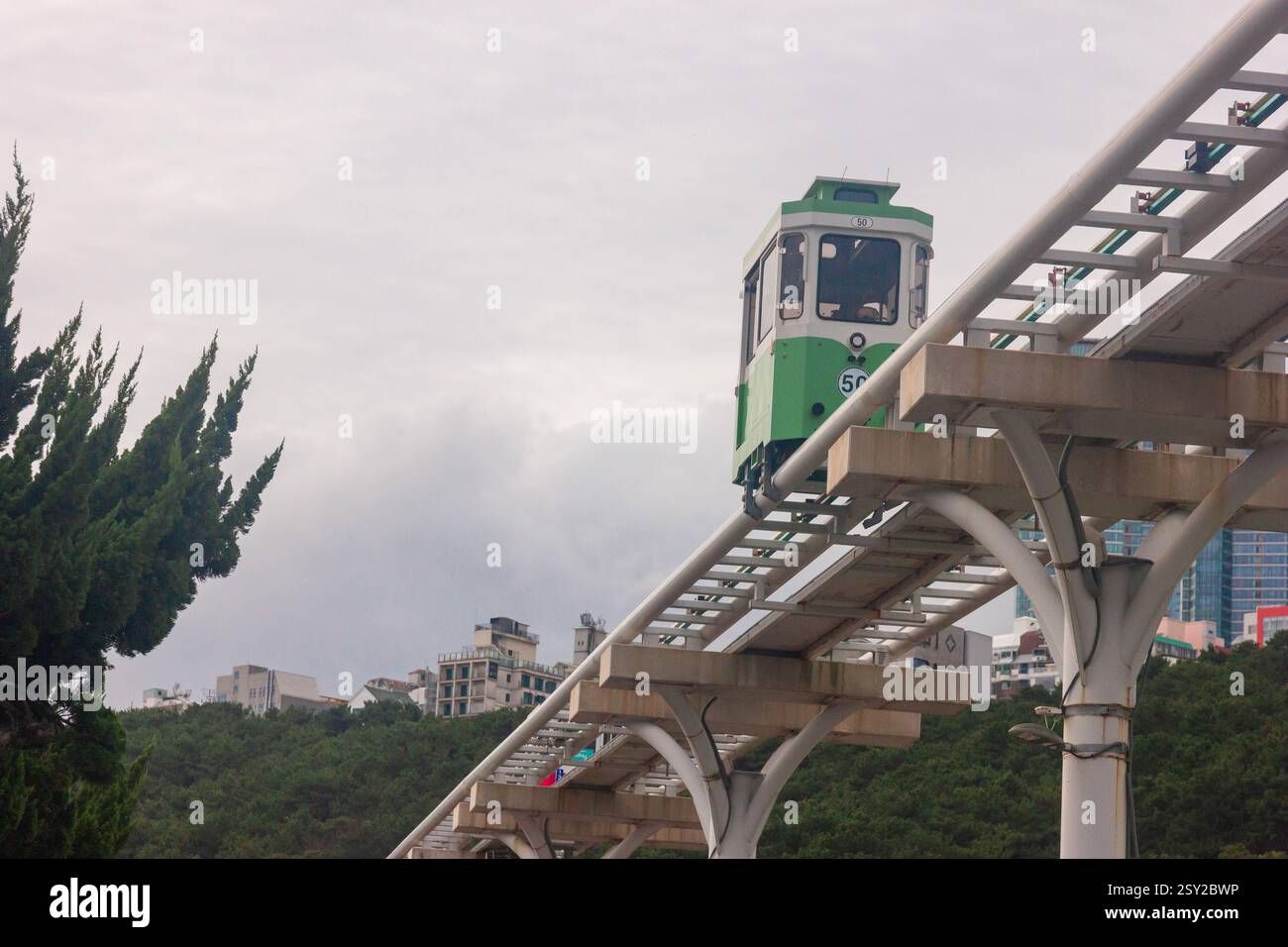 Busan, Corea del Sud - 29 ottobre 2024: Colorati treni a capsula del cielo sulla Busan Green Railway, con un sentiero a piedi e un paesaggio panoramico. Foto Stock