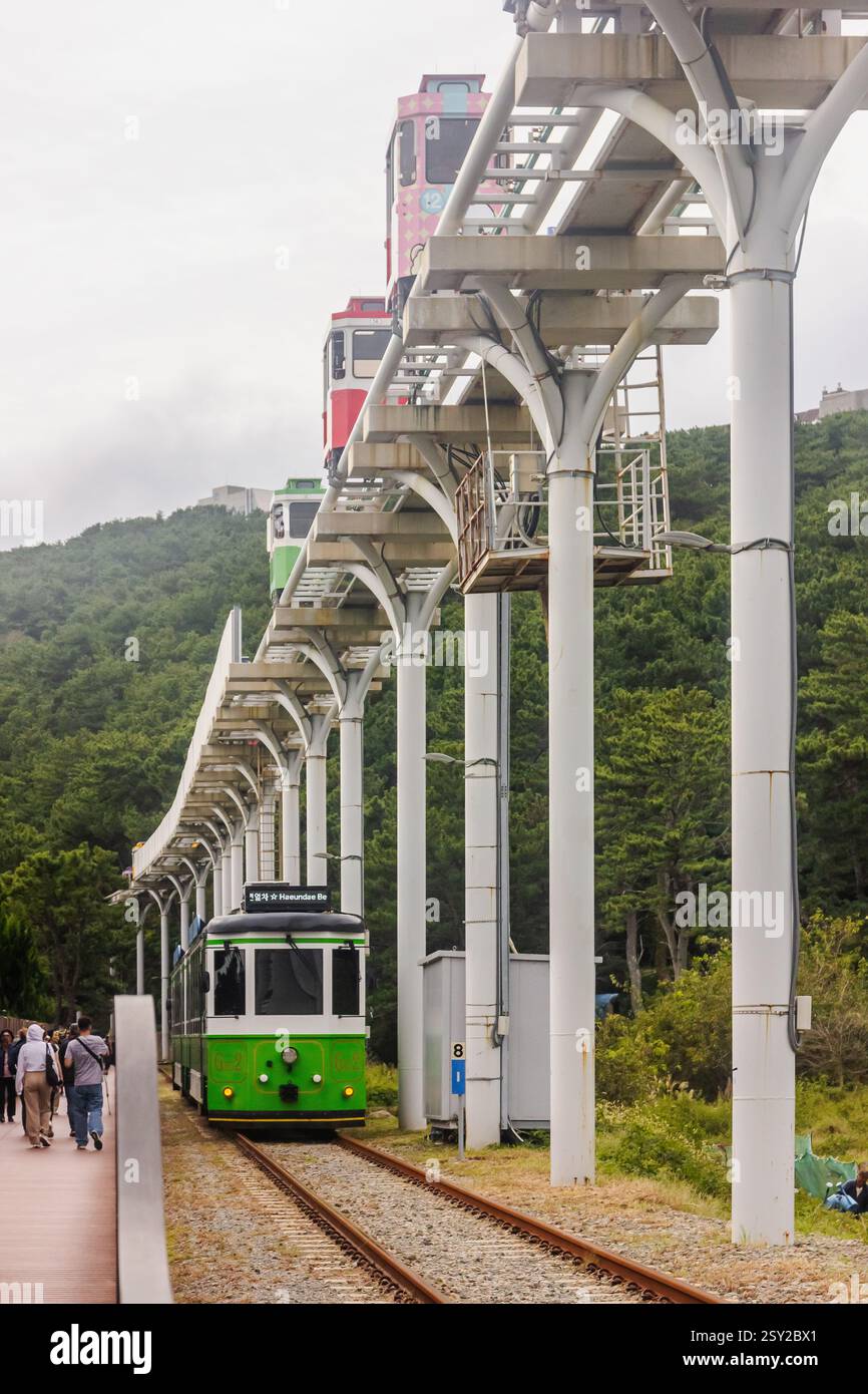 Busan, Corea del Sud - 29 ottobre 2024: Treno sulla spiaggia di Haeundae e treni colorati a capsula del cielo sulla Busan Green Railway a Busan. Foto Stock