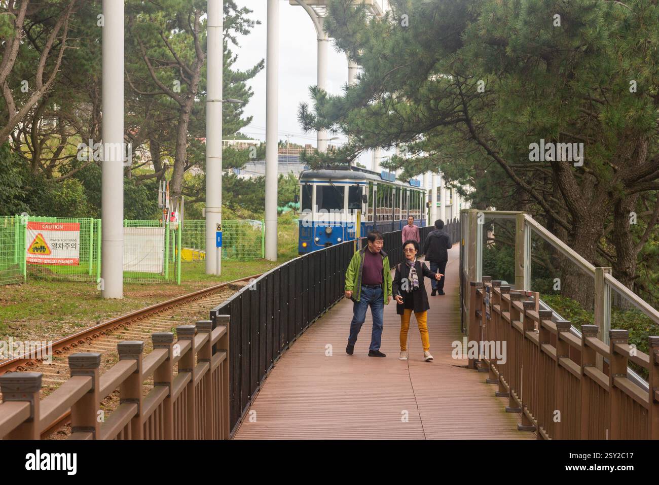 Busan, Corea del Sud - 29 ottobre 2024: Colorati treni a capsula del cielo sulla Busan Green Railway, con un sentiero a piedi e un paesaggio panoramico. Foto Stock