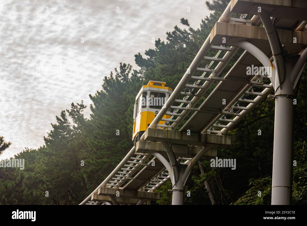 Busan, Corea del Sud - 29 ottobre 2024: Colorati treni a capsula del cielo sulla Busan Green Railway, con un sentiero a piedi e un paesaggio panoramico. Foto Stock