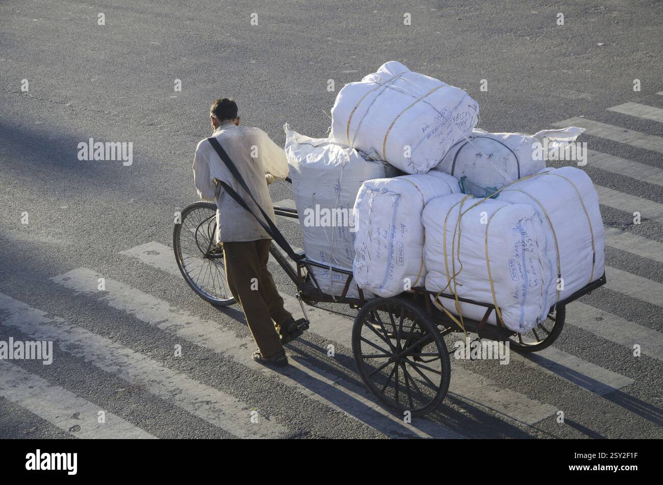 In rickshaw driver ciclo di trascinamento di risciò a Jaipur in Rajasthan in India Foto Stock