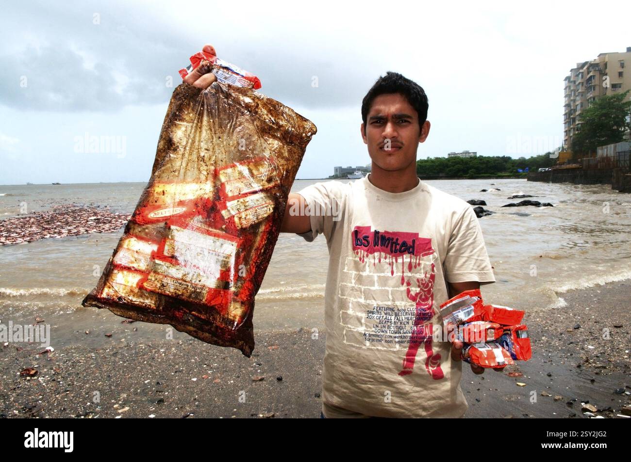 Uomo che mostra pacchetti di biscotti imbevuti di olio a causa della nave container chitra che si scontrano in mare Bombay Mumbai, Maharashtra Foto Stock