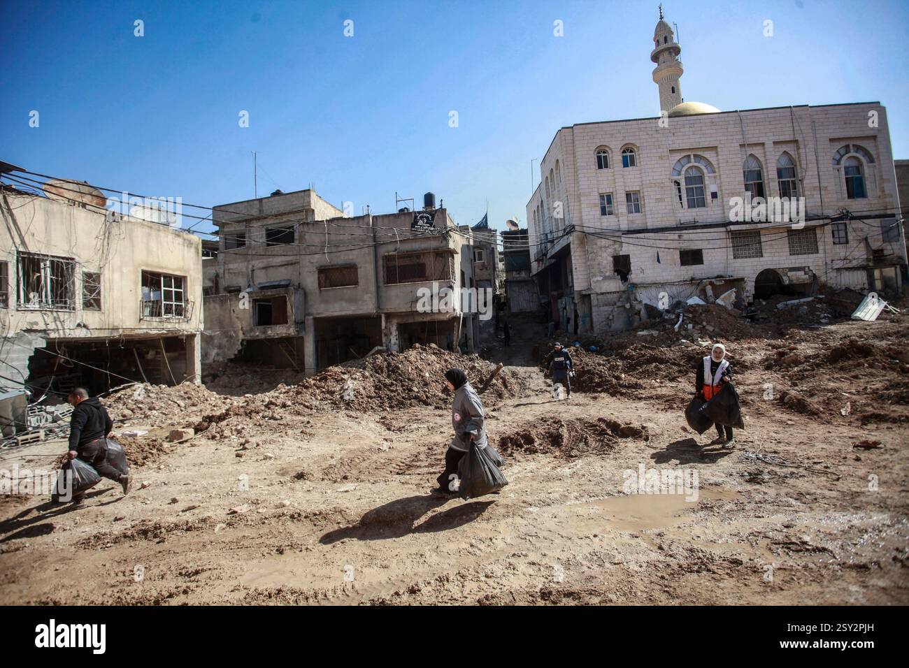 Tulkarm, Palestina. 26 febbraio 2025. Le famiglie palestinesi portano con sé i loro effetti personali, mentre fuggono dal campo profughi di Nour Shams. Le forze israeliane hanno permesso ai residenti di recuperare i loro effetti personali dopo aver emesso avvisi di demolizione per diverse case, nel mezzo di un assalto di settimane in Cisgiordania che ha allontanato circa 30.000 palestinesi dalle loro case all'interno del campo profughi di Nur Shams. Credito: SOPA Images Limited/Alamy Live News Foto Stock