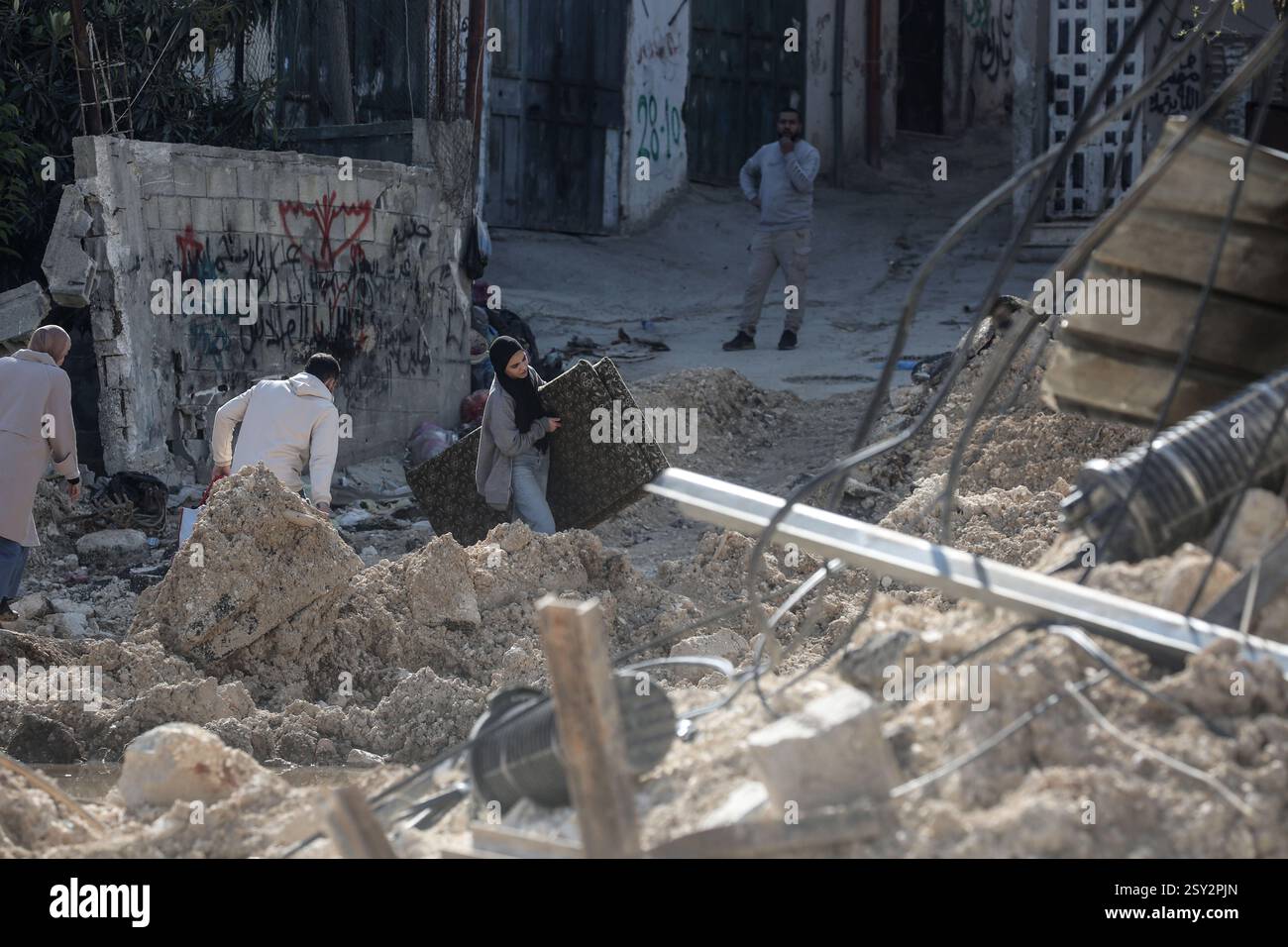 Tulkarm, Palestina. 26 febbraio 2025. Le famiglie palestinesi portano con sé i loro effetti personali, mentre fuggono dal campo profughi di Nour Shams. Le forze israeliane hanno permesso ai residenti di recuperare i loro effetti personali dopo aver emesso avvisi di demolizione per diverse case, nel mezzo di un assalto di settimane in Cisgiordania che ha allontanato circa 30.000 palestinesi dalle loro case all'interno del campo profughi di Nur Shams. Credito: SOPA Images Limited/Alamy Live News Foto Stock