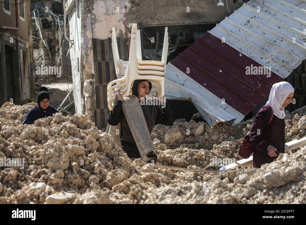 Tulkarm, Palestina. 26 febbraio 2025. Le famiglie palestinesi portano con sé i loro effetti personali, mentre fuggono dal campo profughi di Nour Shams. Le forze israeliane hanno permesso ai residenti di recuperare i loro effetti personali dopo aver emesso avvisi di demolizione per diverse case, nel mezzo di un assalto di settimane in Cisgiordania che ha allontanato circa 30.000 palestinesi dalle loro case all'interno del campo profughi di Nur Shams. Credito: SOPA Images Limited/Alamy Live News Foto Stock