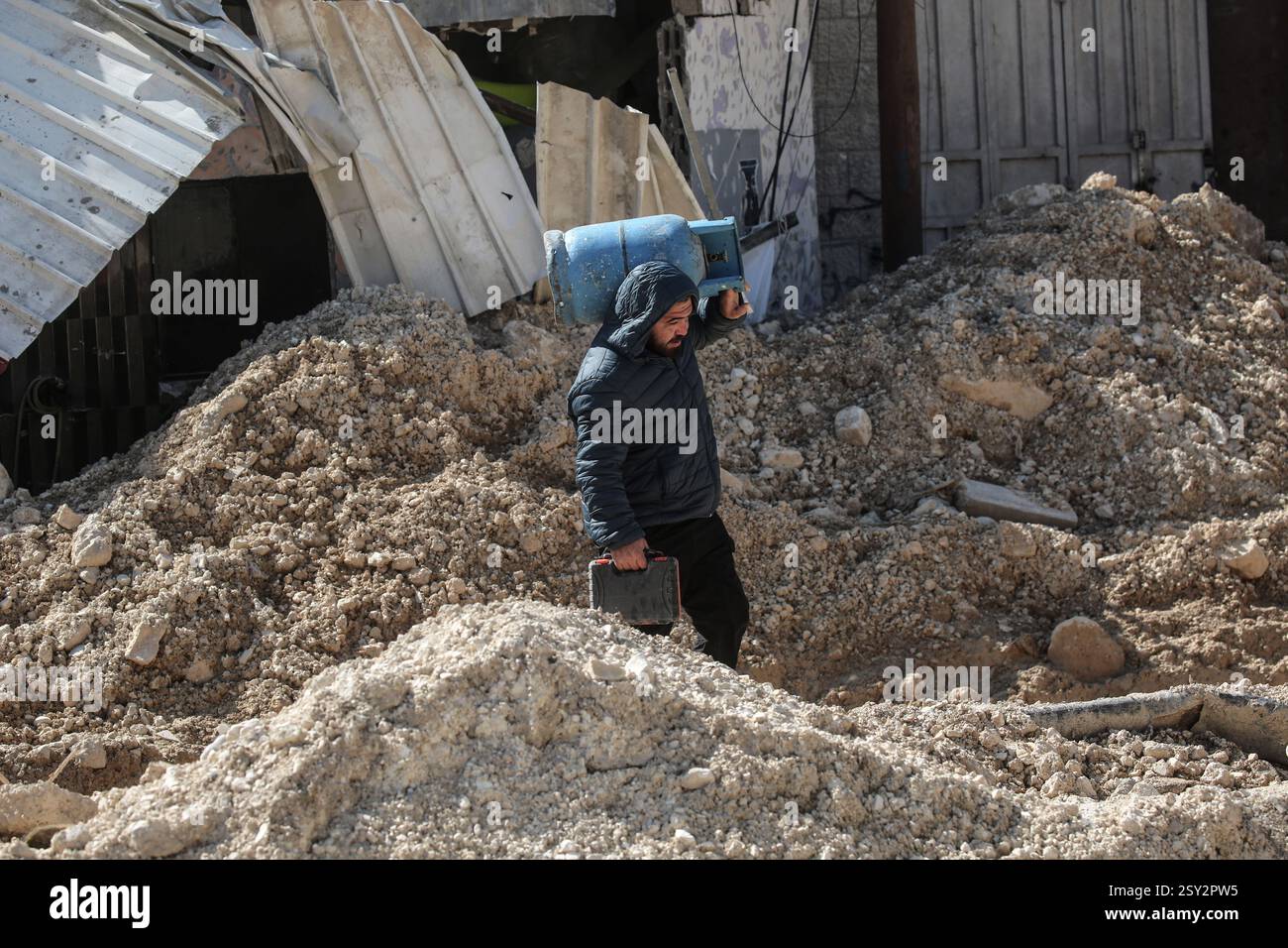 Tulkarm, Palestina. 26 febbraio 2025. Un palestinese porta i suoi effetti personali mentre fugge dal campo profughi di Nour Shams. Le forze israeliane hanno permesso ai residenti di recuperare i loro effetti personali dopo aver emesso avvisi di demolizione per diverse case, nel mezzo di un assalto di settimane in Cisgiordania che ha allontanato circa 30.000 palestinesi dalle loro case all'interno del campo profughi di Nur Shams. Credito: SOPA Images Limited/Alamy Live News Foto Stock