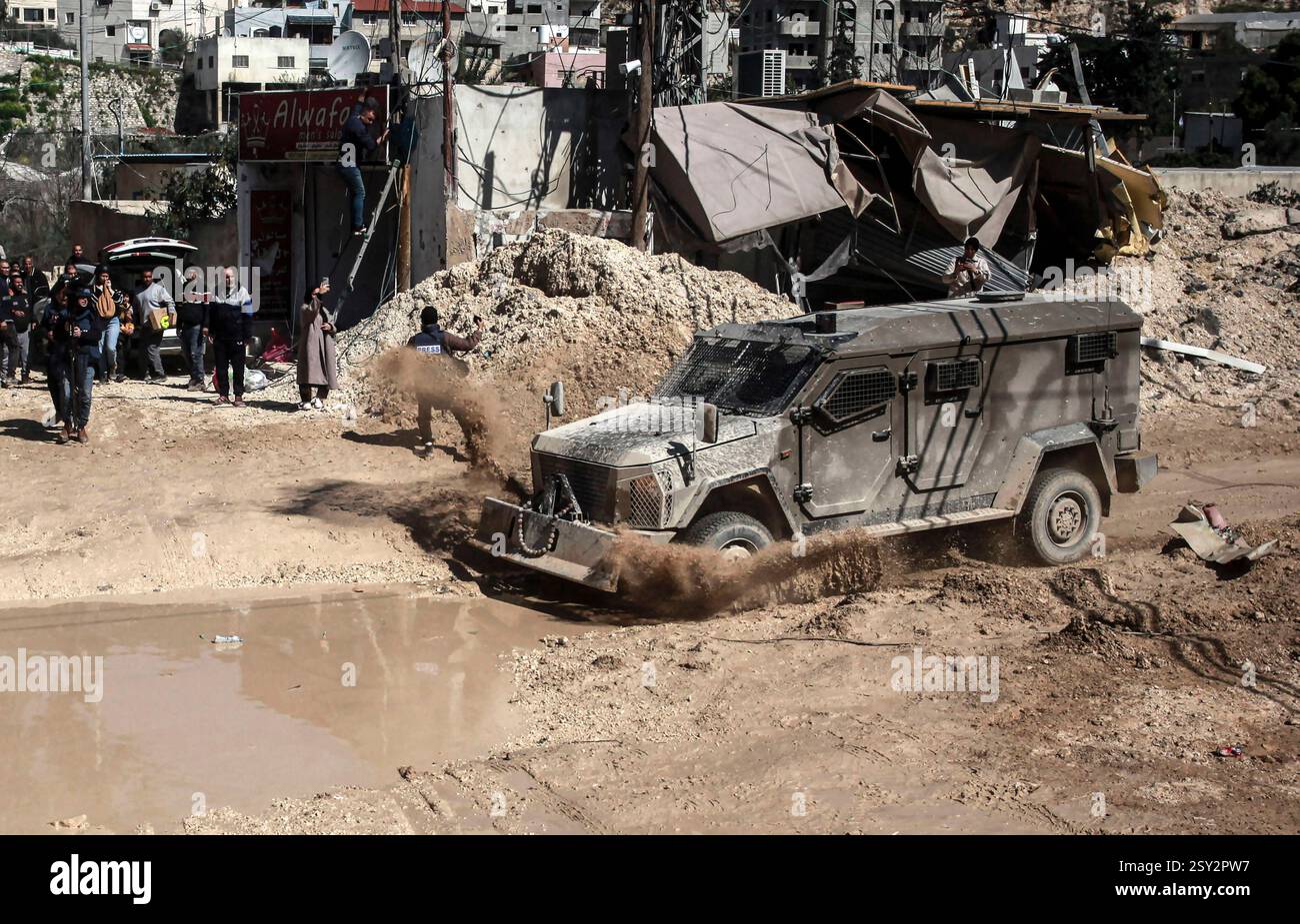 Tulkarm, Palestina. 26 febbraio 2025. Un veicolo militare israeliano pattuglia le strade del campo profughi distrutto di Nur Shams. Le forze israeliane hanno permesso ai residenti di recuperare i loro effetti personali dopo aver emesso avvisi di demolizione per diverse case, nel mezzo di un assalto di settimane in Cisgiordania che ha allontanato circa 30.000 palestinesi dalle loro case all'interno del campo profughi di Nur Shams. Credito: SOPA Images Limited/Alamy Live News Foto Stock