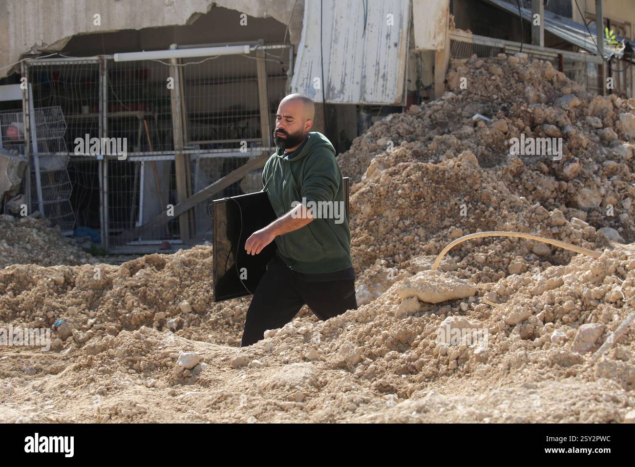Tulkarm, Palestina. 26 febbraio 2025. Un palestinese porta i suoi effetti personali mentre fugge dal campo profughi di Nour Shams. Le forze israeliane hanno permesso ai residenti di recuperare i loro effetti personali dopo aver emesso avvisi di demolizione per diverse case, nel mezzo di un assalto di settimane in Cisgiordania che ha allontanato circa 30.000 palestinesi dalle loro case all'interno del campo profughi di Nur Shams. Credito: SOPA Images Limited/Alamy Live News Foto Stock