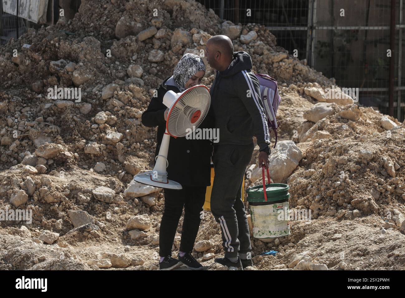 Tulkarm, Palestina. 26 febbraio 2025. Le famiglie palestinesi portano con sé i loro effetti personali, mentre fuggono dal campo profughi di Nour Shams. Le forze israeliane hanno permesso ai residenti di recuperare i loro effetti personali dopo aver emesso avvisi di demolizione per diverse case, nel mezzo di un assalto di settimane in Cisgiordania che ha allontanato circa 30.000 palestinesi dalle loro case all'interno del campo profughi di Nur Shams. Credito: SOPA Images Limited/Alamy Live News Foto Stock