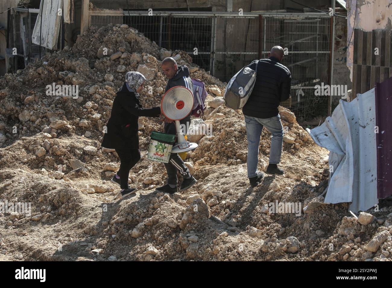 Tulkarm, Palestina. 26 febbraio 2025. Le famiglie palestinesi portano con sé i loro effetti personali, mentre fuggono dal campo profughi di Nour Shams. Le forze israeliane hanno permesso ai residenti di recuperare i loro effetti personali dopo aver emesso avvisi di demolizione per diverse case, nel mezzo di un assalto di settimane in Cisgiordania che ha allontanato circa 30.000 palestinesi dalle loro case all'interno del campo profughi di Nur Shams. Credito: SOPA Images Limited/Alamy Live News Foto Stock