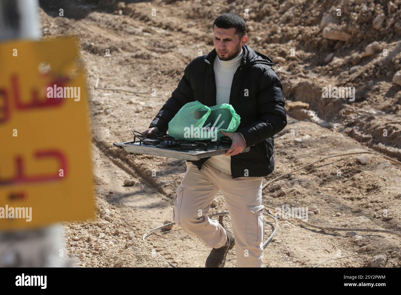 Tulkarm, Palestina. 26 febbraio 2025. Un palestinese porta i suoi effetti personali mentre fugge dal campo profughi di Nour Shams. Le forze israeliane hanno permesso ai residenti di recuperare i loro effetti personali dopo aver emesso avvisi di demolizione per diverse case, nel mezzo di un assalto di settimane in Cisgiordania che ha allontanato circa 30.000 palestinesi dalle loro case all'interno del campo profughi di Nur Shams. Credito: SOPA Images Limited/Alamy Live News Foto Stock