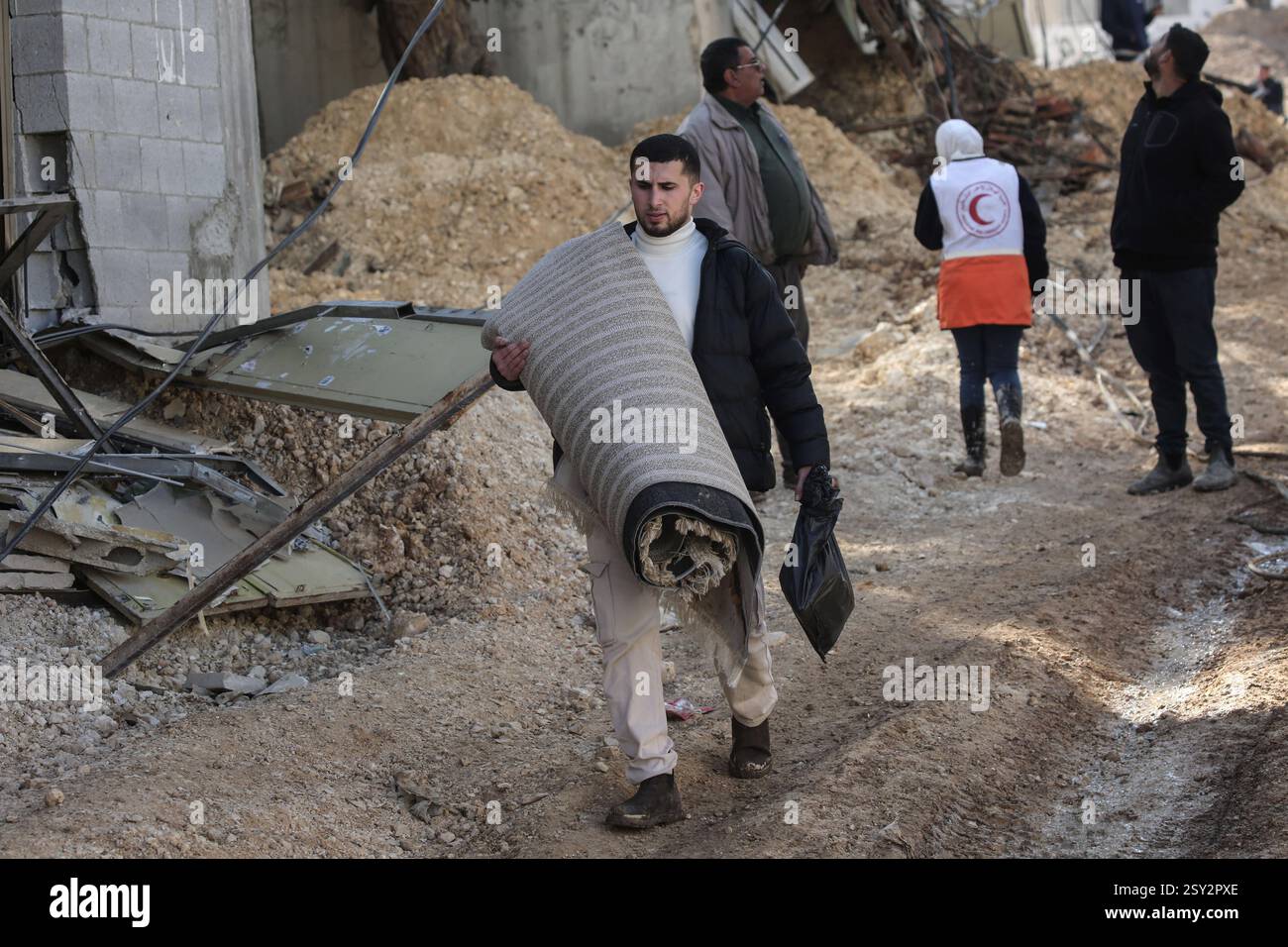 Tulkarm, Palestina. 26 febbraio 2025. Le famiglie palestinesi portano con sé i loro effetti personali, mentre fuggono dal campo profughi di Nour Shams. Le forze israeliane hanno permesso ai residenti di recuperare i loro effetti personali dopo aver emesso avvisi di demolizione per diverse case, nel mezzo di un assalto di settimane in Cisgiordania che ha allontanato circa 30.000 palestinesi dalle loro case all'interno del campo profughi di Nur Shams. Credito: SOPA Images Limited/Alamy Live News Foto Stock