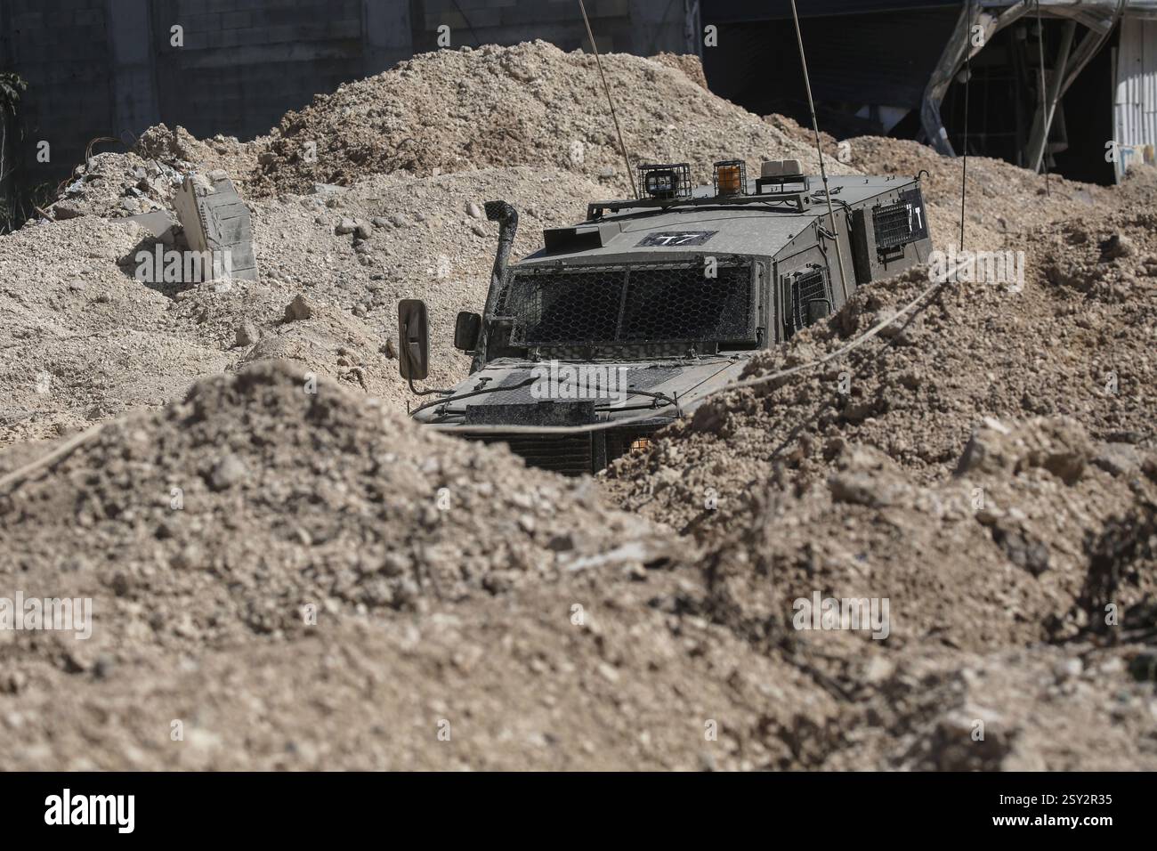 Tulkarm, Palestina. 26 febbraio 2025. Un veicolo militare israeliano pattuglia le strade del campo profughi distrutto di Nur Shams. Le forze israeliane hanno permesso ai residenti di recuperare i loro effetti personali dopo aver emesso avvisi di demolizione per diverse case, nel mezzo di un assalto di settimane in Cisgiordania che ha allontanato circa 30.000 palestinesi dalle loro case all'interno del campo profughi di Nur Shams. Credito: SOPA Images Limited/Alamy Live News Foto Stock