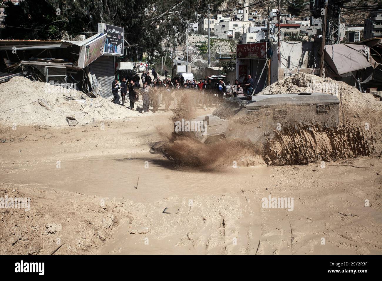 Tulkarm, Palestina. 26 febbraio 2025. Un veicolo militare israeliano pattuglia le strade del campo profughi distrutto di Nur Shams. Le forze israeliane hanno permesso ai residenti di recuperare i loro effetti personali dopo aver emesso avvisi di demolizione per diverse case, nel mezzo di un assalto di settimane in Cisgiordania che ha allontanato circa 30.000 palestinesi dalle loro case all'interno del campo profughi di Nur Shams. Credito: SOPA Images Limited/Alamy Live News Foto Stock