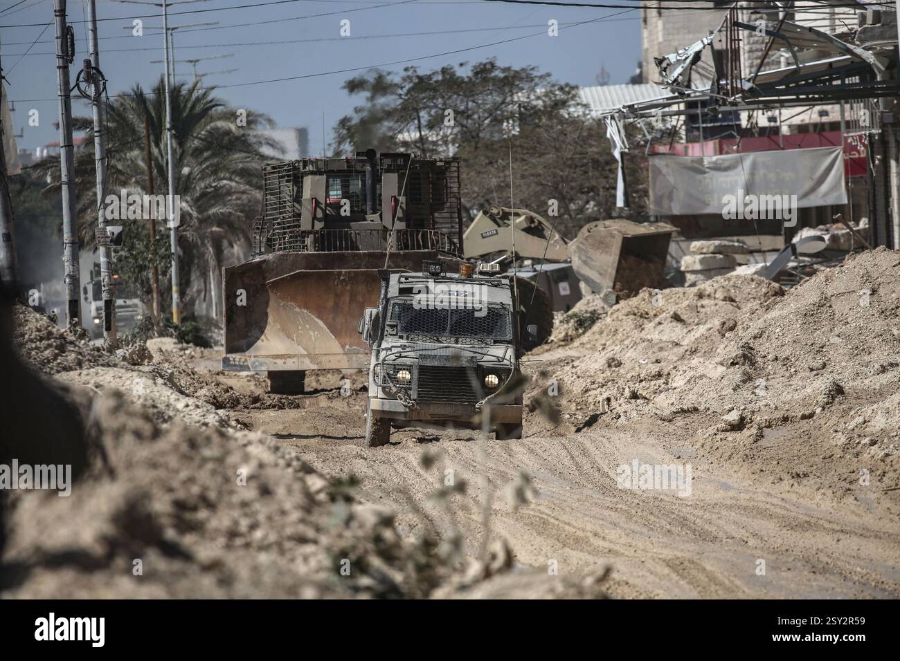 Tulkarm, Palestina. 26 febbraio 2025. Un veicolo militare israeliano pattuglia le strade del campo profughi distrutto di Nur Shams. Le forze israeliane hanno permesso ai residenti di recuperare i loro effetti personali dopo aver emesso avvisi di demolizione per diverse case, nel mezzo di un assalto di settimane in Cisgiordania che ha allontanato circa 30.000 palestinesi dalle loro case all'interno del campo profughi di Nur Shams. Credito: SOPA Images Limited/Alamy Live News Foto Stock