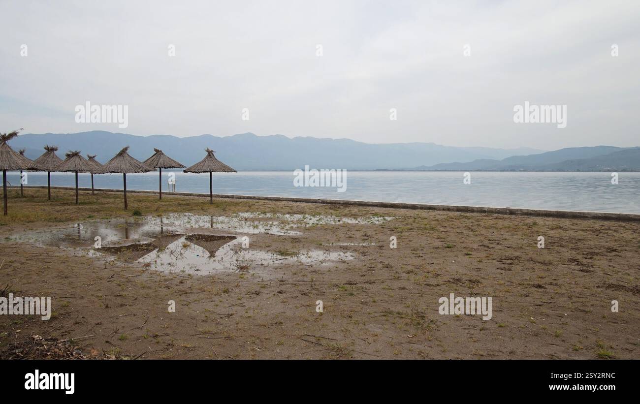 Winter Silence – ombrelloni di paglia su una spiaggia deserta Foto Stock