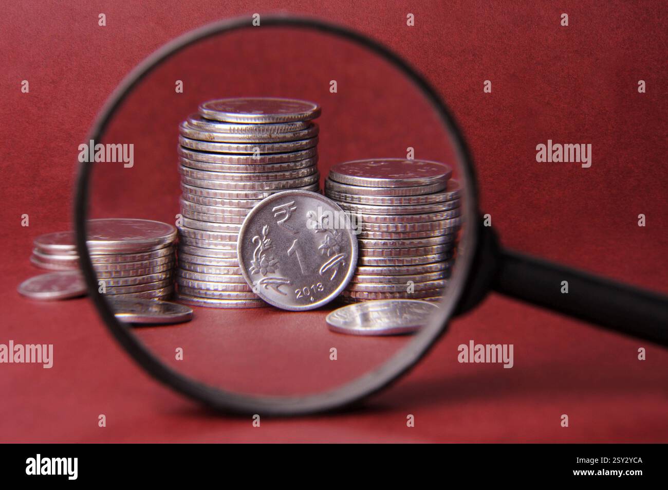 Concetto di lente d'ingrandimento e moneta Foto Stock