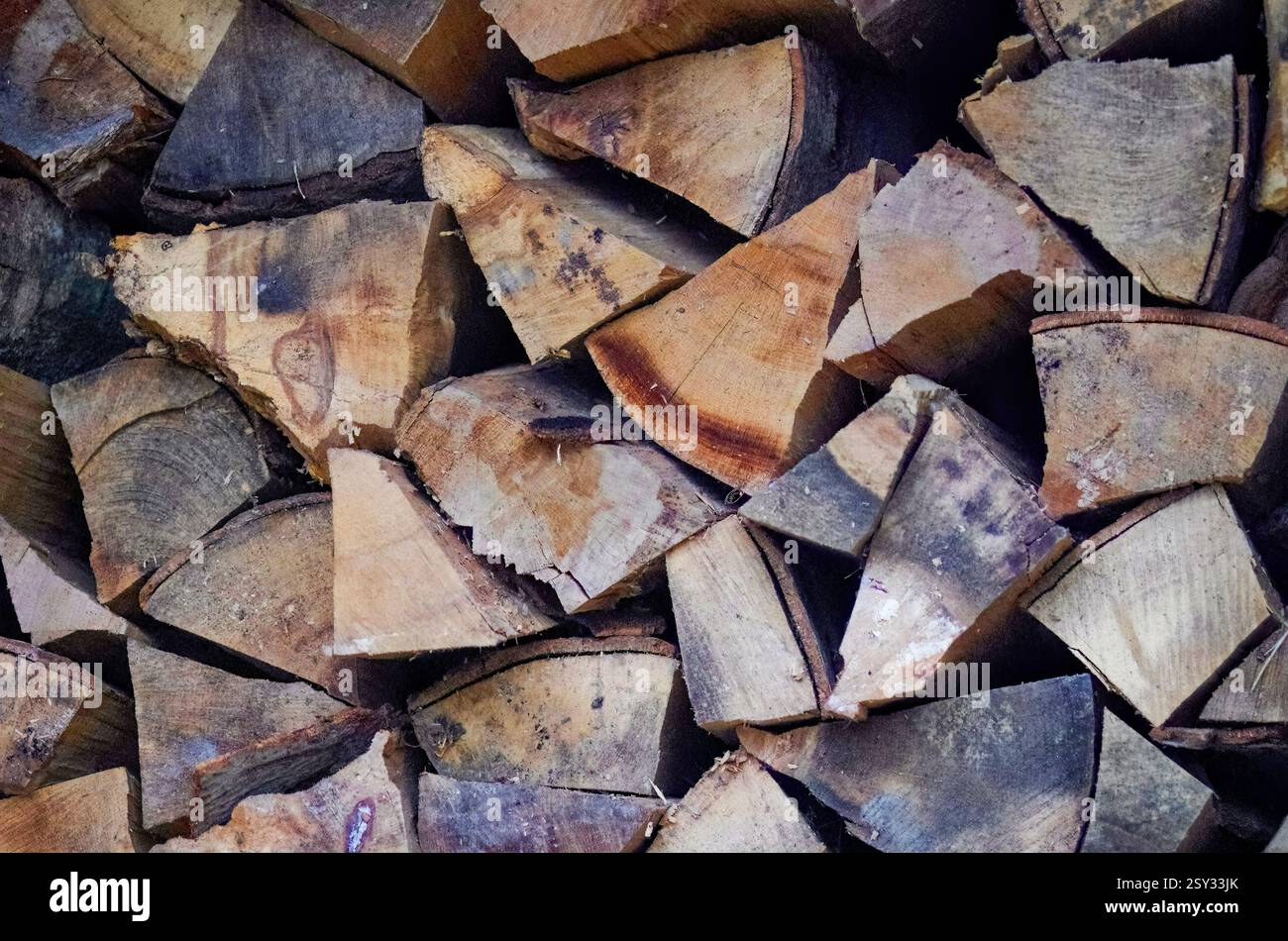 Una vista dettagliata della legna da ardere tritata disposta in un mucchio, mostrando forme irregolari, motivi di grana, nodi e texture naturali nel legno. Foto Stock