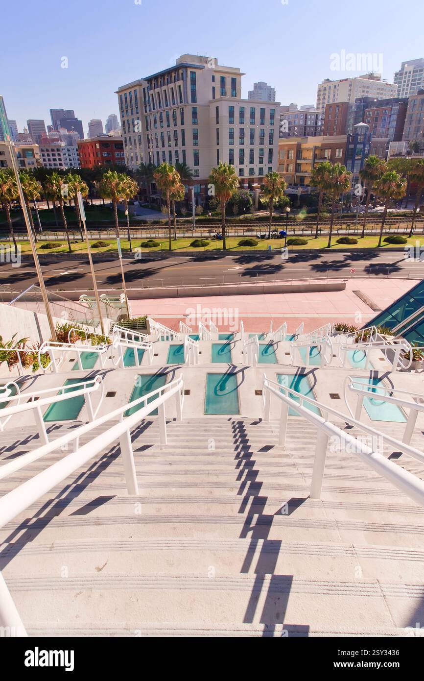 Vista della città con un alto edificio sullo sfondo. Le scale che portano all'edificio sono bianche e verdi Foto Stock