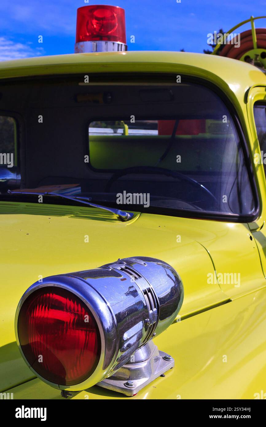 Veicolo d'epoca giallo con luce rossa sul retro. La luce è uno stile classico con una finitura cromata. Il camion è parcheggiato in un parcheggio, e il li Foto Stock
