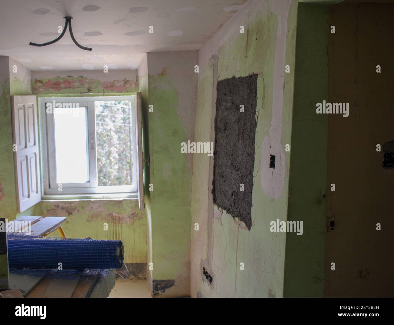 le pareti di una vecchia casa saranno lucidate per essere poi dipinte di bianco Foto Stock