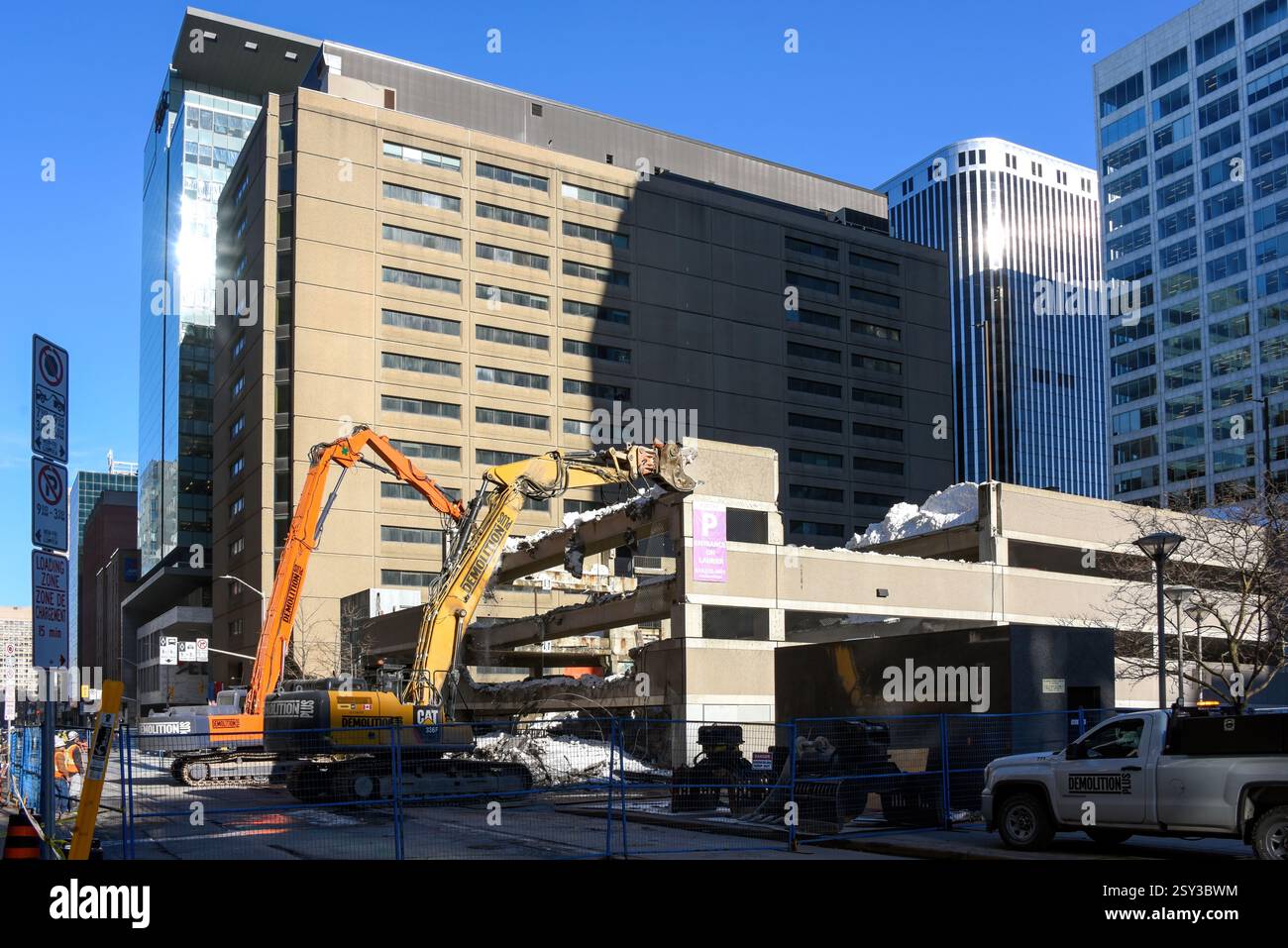 Ottawa, Canada - 26 febbraio 2024: Le gru lavorano per rimuovere neve e detriti da un garage multilivello in Slater Street, nel centro città. Una parte del garage è crollata la mattina presto, inviando mucchi di neve e cemento giù per tre livelli a terra e danneggiando diversi veicoli. La causa non è ancora stata determinata, ma potrebbe essere dovuta all'elevato livello di neve che non era ancora stato eliminato. La città ha ricevuto 70 centimetri di neve tra il 12 febbraio e il 16 febbraio. Foto Stock