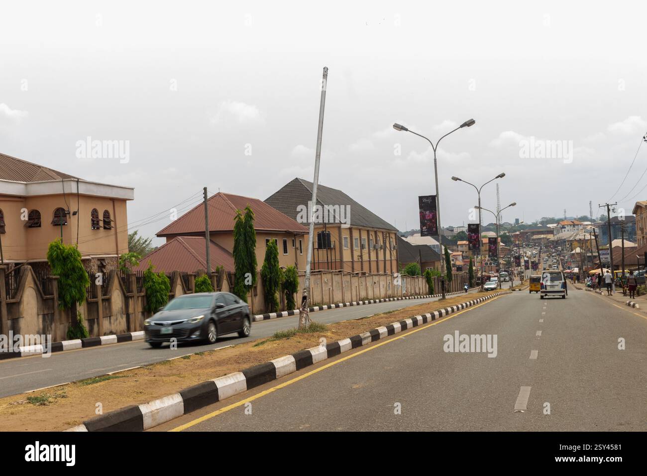 Lower Presidential Road Enugu con veicoli, lampioni ed edifici, paesaggio urbano della Nigeria che mostra trasporti, infrastrutture e sviluppo Foto Stock