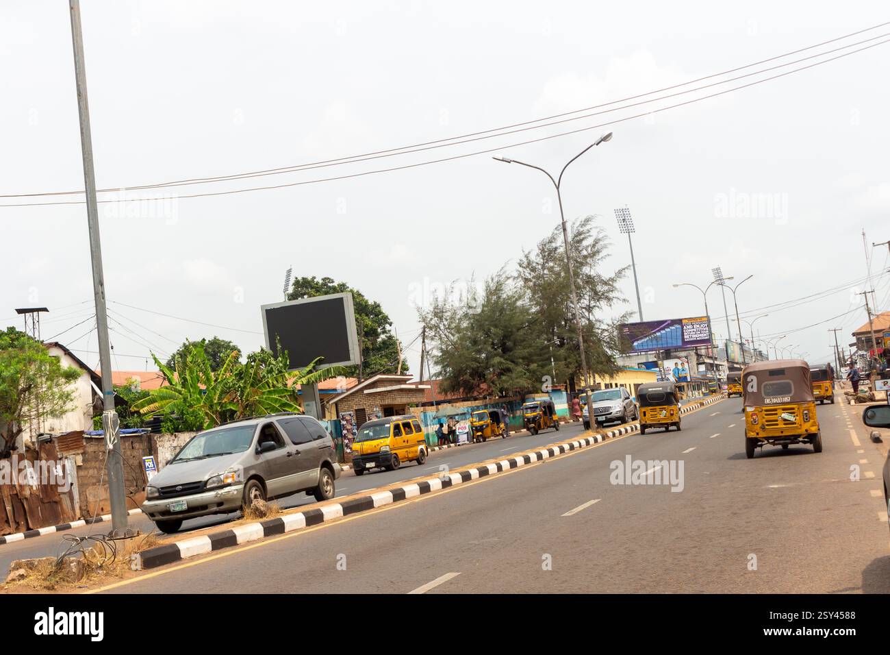 Okpara Avenue Enugu Street view con edifici, strade asfaltate, segnaletica stradale e veicoli, paesaggio urbano della Nigeria illustrazione di infrastrutture Foto Stock