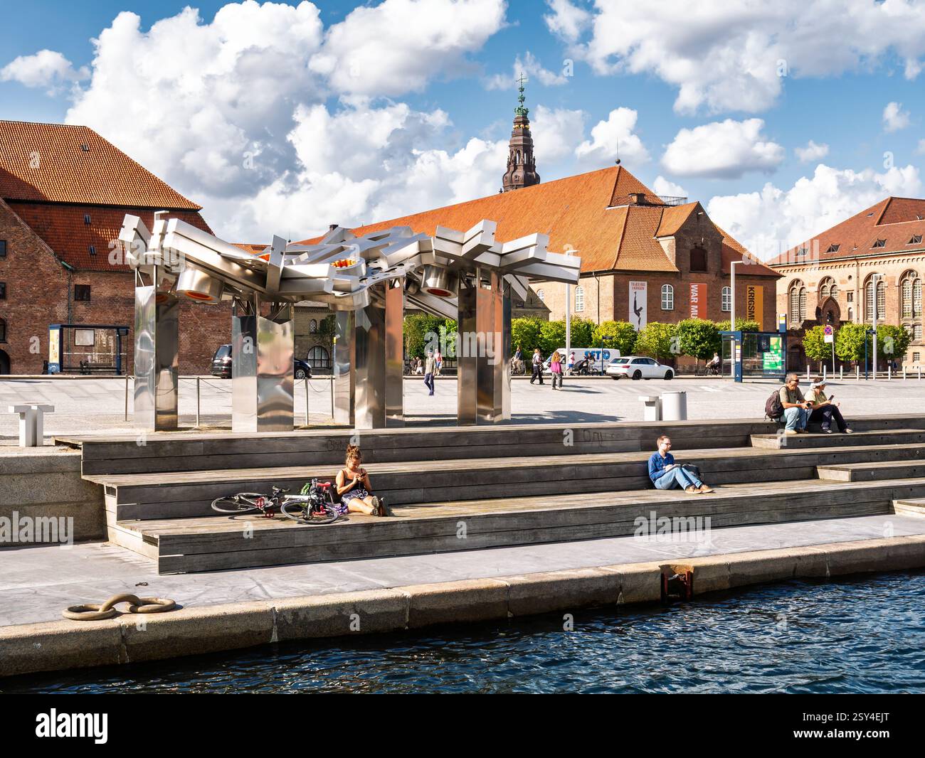Persone che si rilassano sul lungomare del porto interno e sculture d'arte pubblica a Søren Kierkegaards Plads, Copenaghen, Danimarca Foto Stock