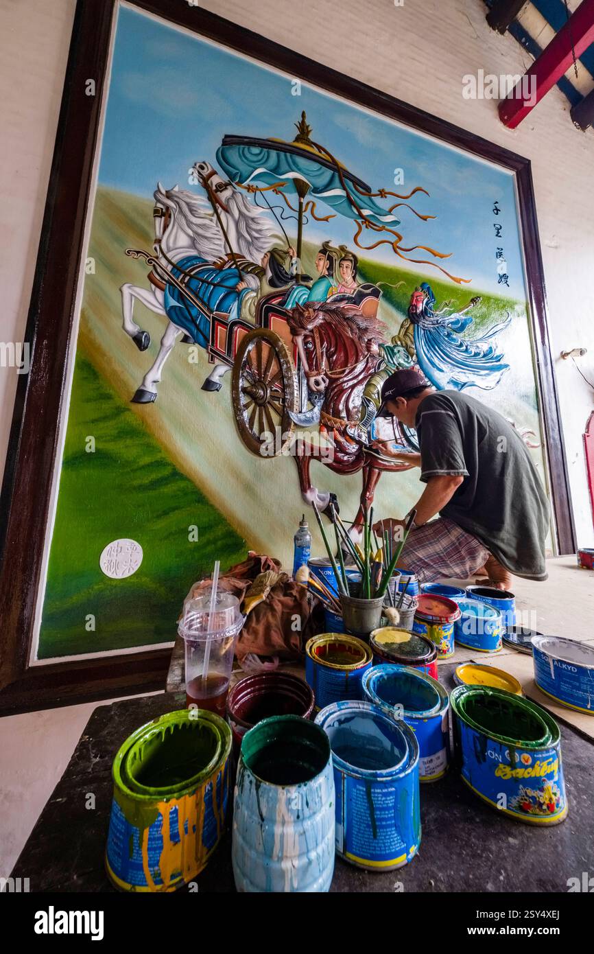 Un artista ripristina un grande murale nella Phuoc Kien Assembly Hall di Hoi An, Hái An, originariamente un luogo di incontro e centro commerciale per i cinesi Foto Stock