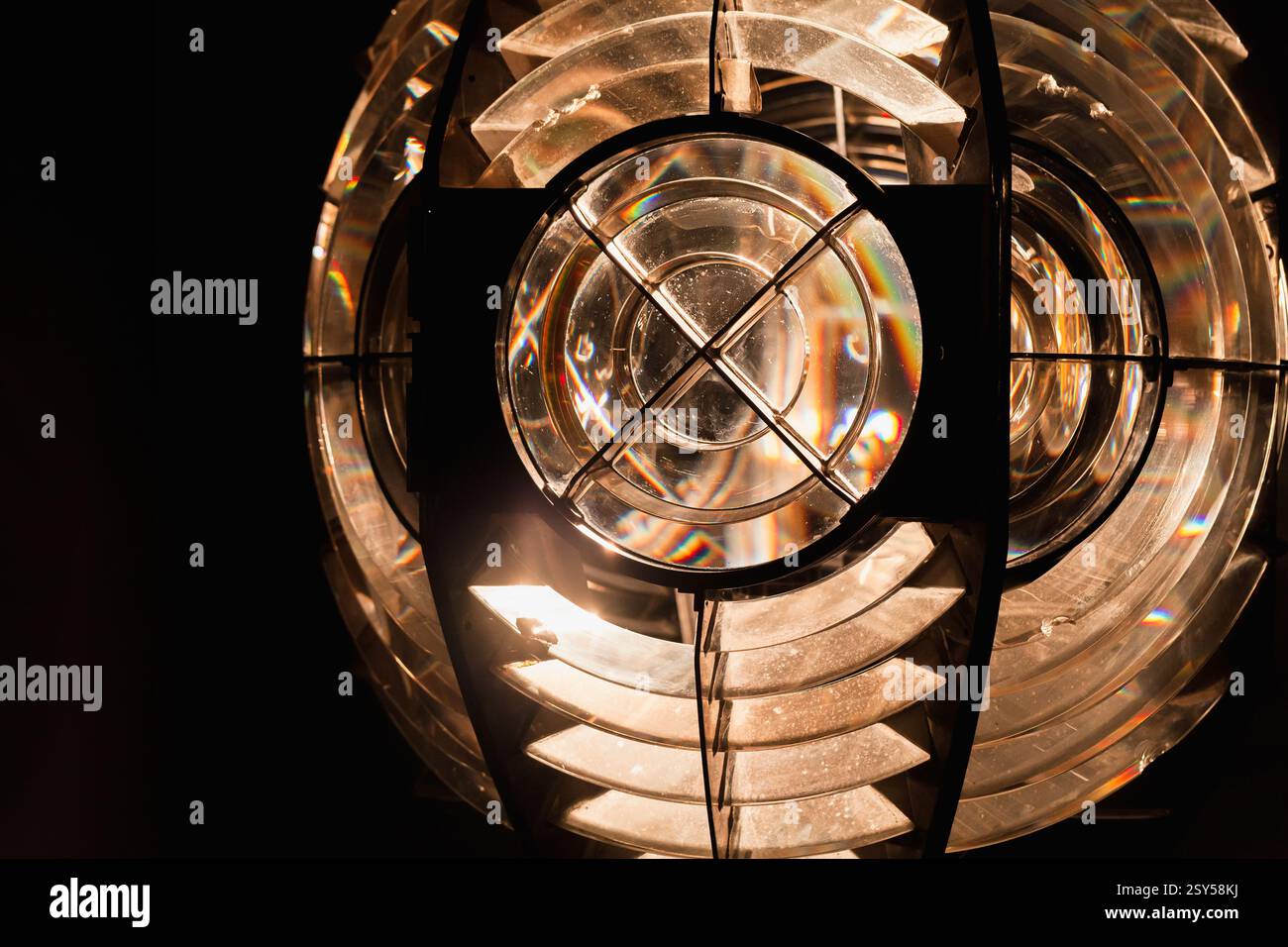 L'intricato design di una grande lente Fresnel è caratterizzato da colori prismatici che rivelano la luce e da una cura artigianale dettagliata che rappresenta l'illuminazione Foto Stock