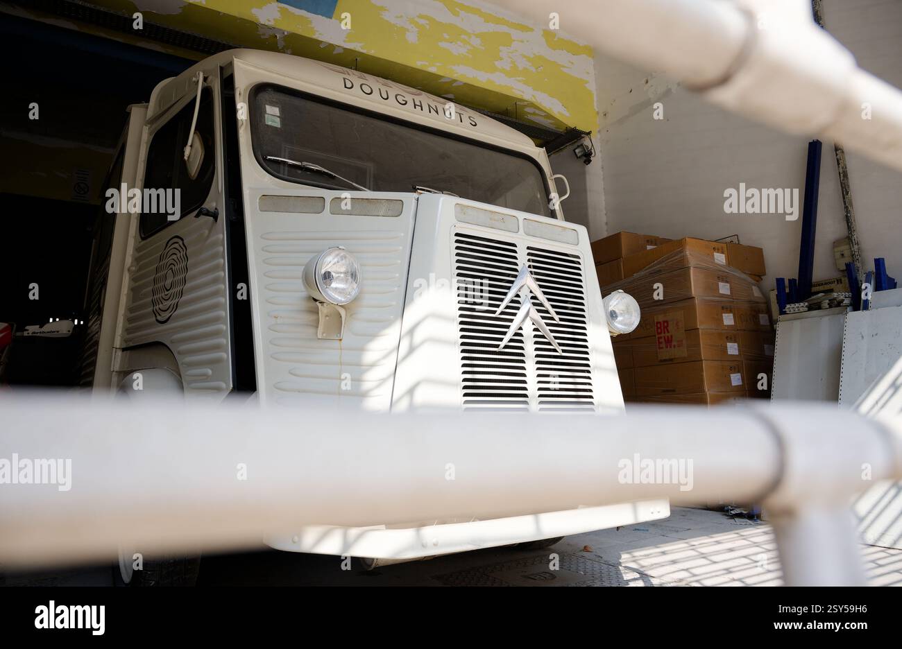 Un furgone alimentare bianco d'epoca Citroën con le "ciambelle" in cima, parcheggiato all'interno di un magazzino Foto Stock