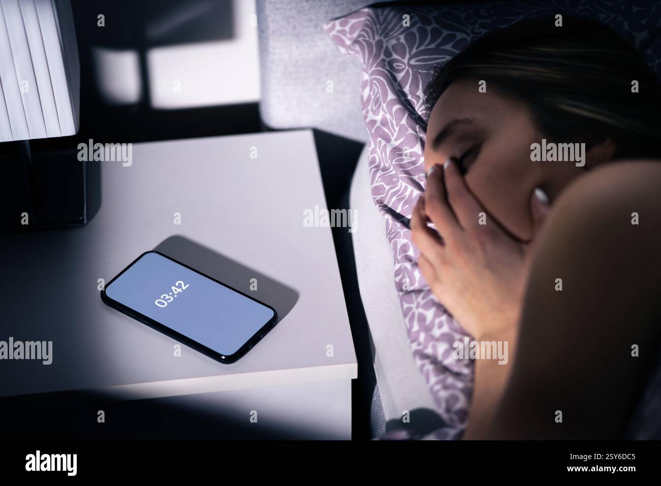 Sonno e insonnia. Donna con apnea o disturbo di notte. Persona insonne con ansia e problemi. Sveglia nel telefono sul tavolo. Foto Stock