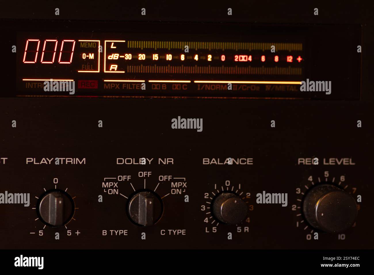 Primo piano di un deck audio a nastro retrò con pannello retroilluminato, comandi analogici e quadranti, che mostrano un'estetica nostalgica della classica tecnologia retrò. Foto Stock